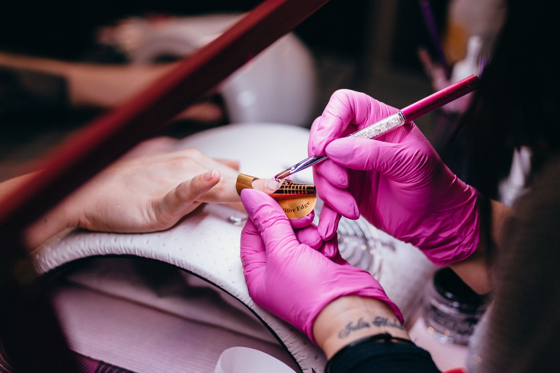 Nail technician applying polish during a manicure