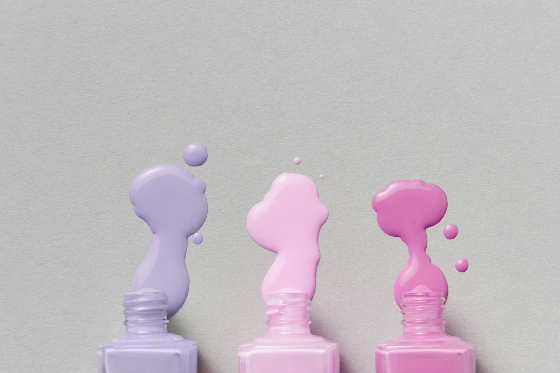 Three pastel nail polish bottles with glossy drips